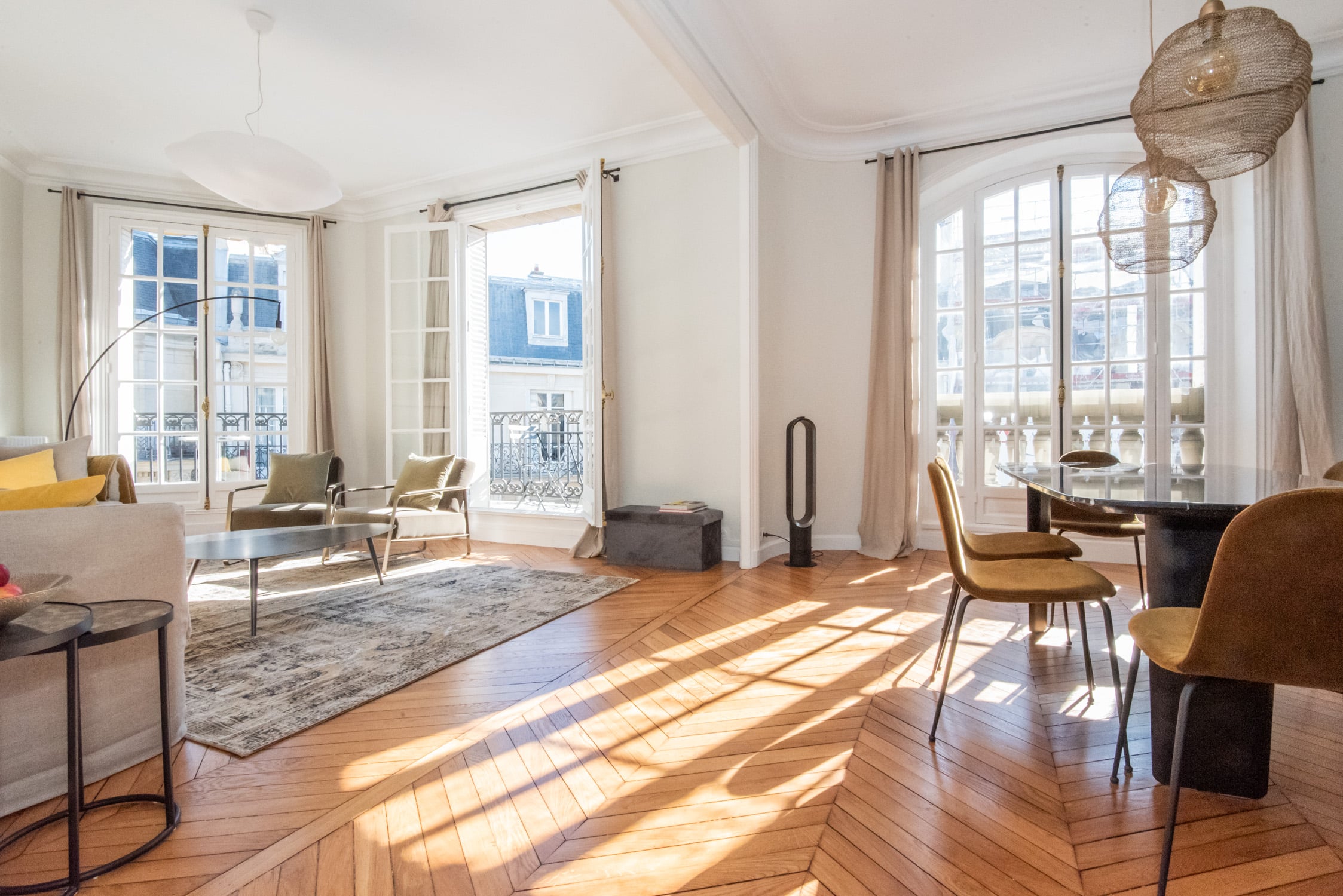 Luxurious Parisian apartment with soaring ceilings, expansive French windows, and abundant natural light. Elegant hardwood floors, sophisticated furnishings, and panoramic city views.