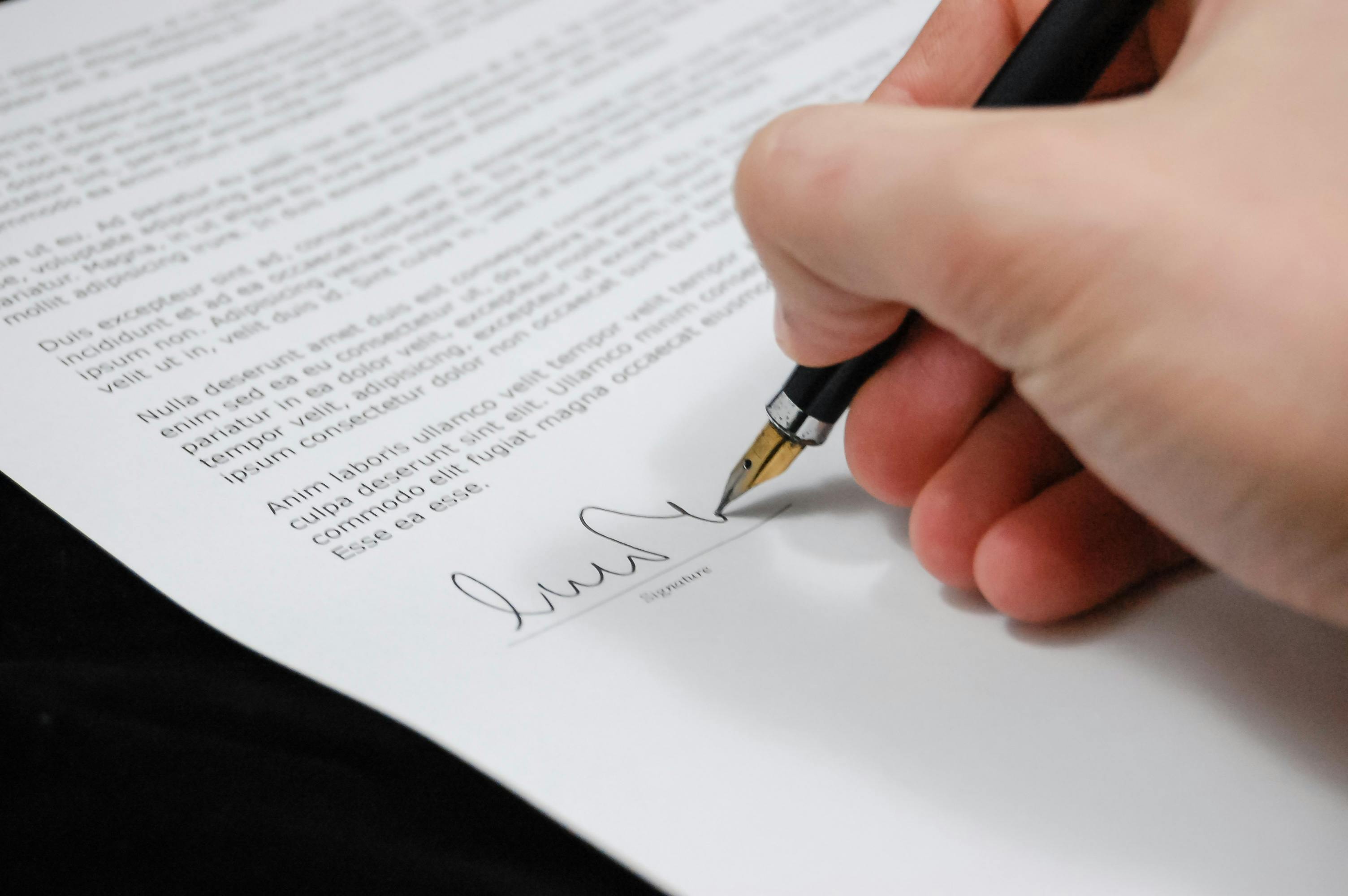 Signature on luxury rental contract with fountain pen, professional document signing for premium property lease agreement.